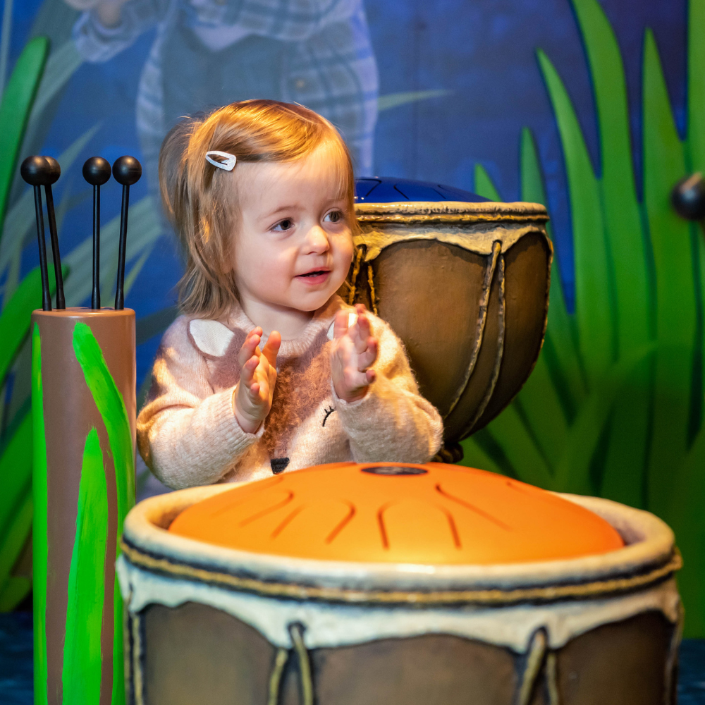 Child playing drums in Jeremy Fisher's Pond