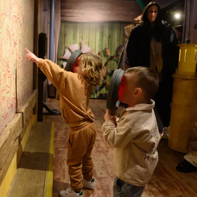 Children with magnifying glasses in Mr Bouncer's Workshop