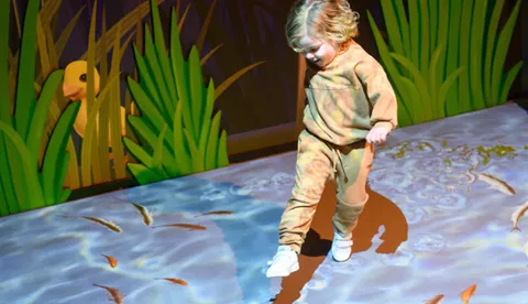 Child walking through Jeremy Fisher's sensory pond
